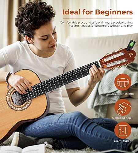 Person playing a classical guitar with tuning device attached.