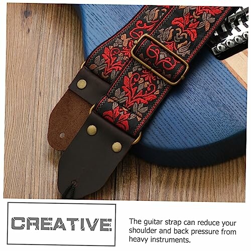 Decorative guitar strap with floral pattern on a blue guitar.